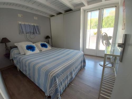 西让Maison de pecheur的一间卧室配有一张带蓝色枕头的床