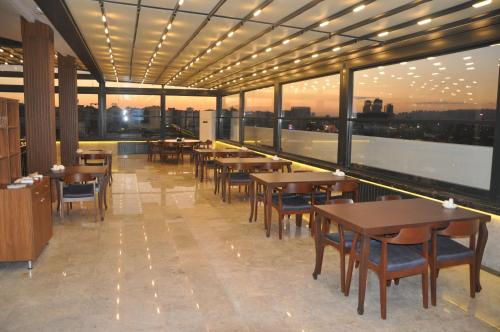 安卡拉GOLAZ SUİT OTEL的餐厅设有桌椅和大窗户。