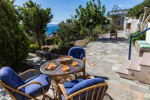 爱琴娜岛Villa Euphoria Studio in Aegina, A' Marathonas Bay的一个带桌椅的庭院和大海