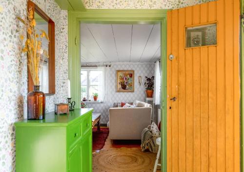 厄勒布鲁Stuga med lantlig känsla nära Örebro city的一间设有绿色橱柜的房间和一间客厅