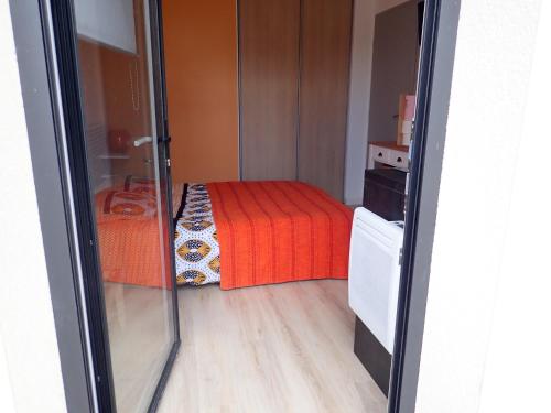 HillionProche GR34 , Studio "Estrella" , petit cocon accueillant的小房间,配有一张带红色毯子的床