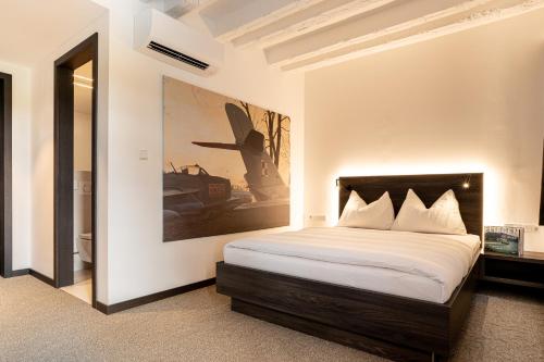 Hotel Spitzerberg by b-smart的卧室配有一张床,墙上挂有绘画作品