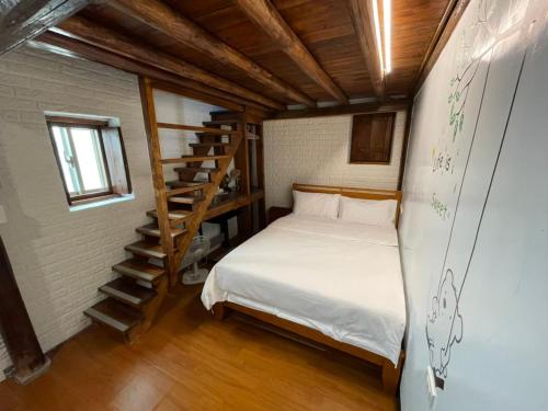 北竿芹壁德顺号民宿2馆的一间小卧室,配有一张床和一个楼梯