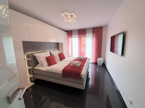 巴特克罗伊茨纳赫Ihr Ticket ins Grüne - Topmoderne 5-Sterne-Ferienwohnung的一间卧室配有红色和白色枕头的床