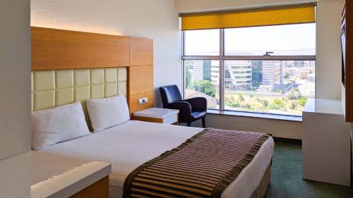 开塞利努兹赫特酒店的酒店的客房 - 带一张床、椅子和窗户
