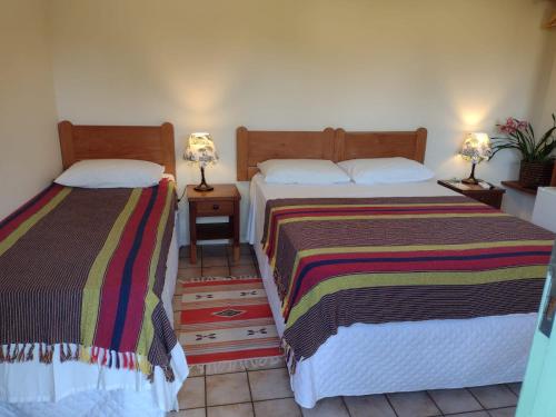 圣塞巴斯蒂安Pousada Ana Doce的两张睡床彼此相邻,位于一个房间里