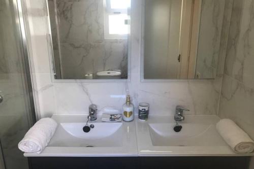 米哈斯Ático con terraza abierta/Open terrace apartment的白色的浴室设有两个盥洗盆和镜子
