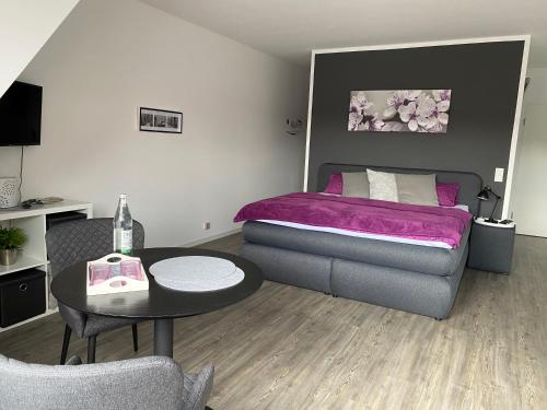 迪尔门City-Apartment Dülmen的一间卧室配有一张床、一张桌子和一张沙发