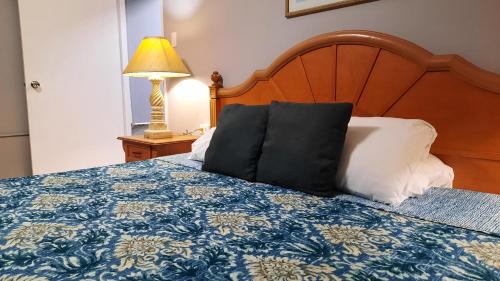 棕榈滩阿鲁巴昆库公寓式酒店的一张带蓝色和白色毯子和灯的床