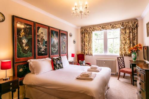 凯尔索爱德纳姆之家酒店的一间卧室配有一张大床和一个吊灯。