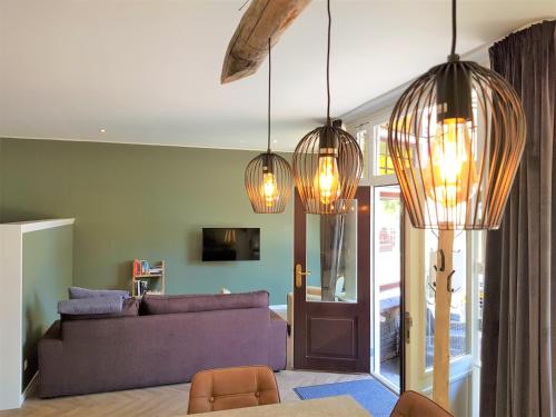 巴勒哈姆斯泰德Appartement "Hartje Haamstede"的客厅配有紫色沙发和三盏灯