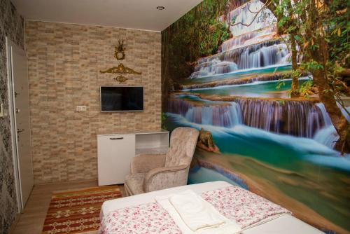 帕莫卡莱圣特特拉斯酒店的卧室的墙上挂有瀑布壁画