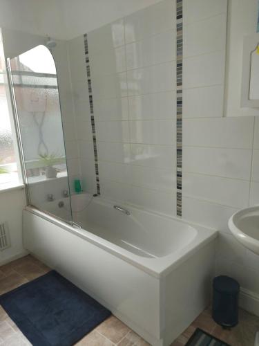 斯卡伯勒Sandyrise holiday lets的白色的浴室设有浴缸和水槽。