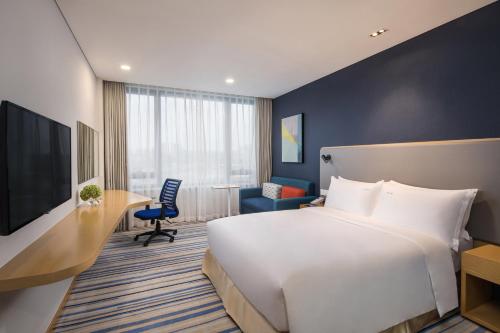 无锡无锡太湖新城智选假日酒店的酒店客房设有一张大床和一张书桌。
