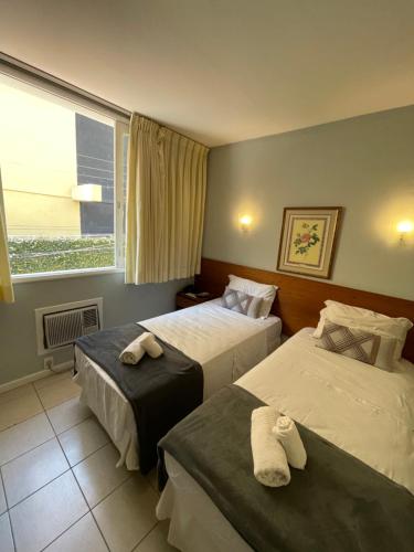 尼泰罗伊Hotel Petit Village Icaraí的两张位于酒店客房的床,配有毛巾