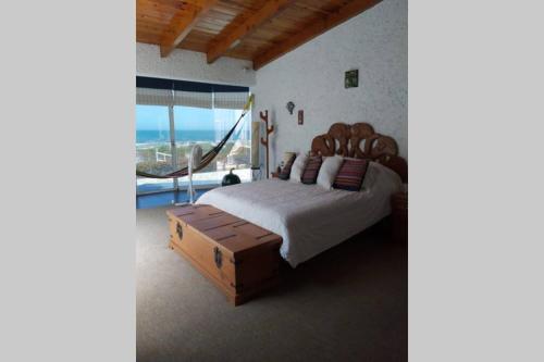 恩塞纳达港CASA DE PLAYA EN ENSENADA的一间卧室设有一张大床和一个大窗户