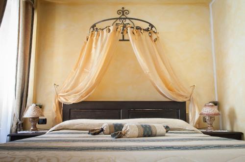 瓦斯托洛坎达狄巴洛尼酒店的一间卧室配有一张大床和窗帘
