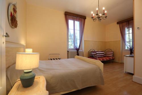 Saint-Romain-de-LerpsVilla Rouvesol的一间卧室配有一张床和一张桌子上的台灯
