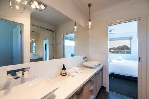 伊丘卡Mandel on High - Echuca Holiday Homes的一间带水槽和镜子的浴室以及一张床