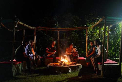 比姆塔尔Cottages @ Village的一群人晚上坐在火炉旁