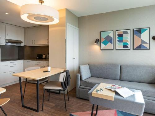 伦敦Aparthotel Adagio London Stratford的客厅配有沙发和桌子