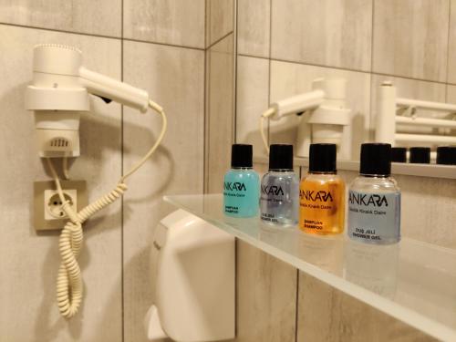 安卡拉CONCEPT HoUSE的浴室在电话旁的架子上装有四瓶