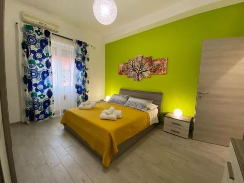 罗马Mimma’s house Monteverde的绿色卧室配有带2条毛巾的床