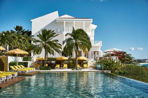Meads BayMalliouhana Resort Anguilla的白色建筑前的游泳池