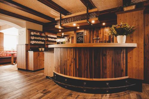 KernhofGasthof Gschoadwirt的餐厅内拥有木墙的酒吧