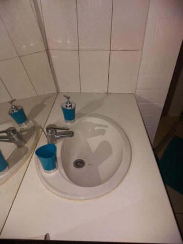 MamoudzouLÃCAZÈRĂ Sãfãrì的浴室里设有白色水槽和蓝色杯子