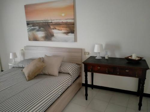索里Oltre Mare的一间卧室配有一张带书桌和绘画的床。