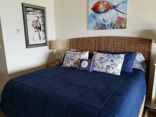 East EndLuxury Sapphire Beach Resort and Marina 1BR VII的一间卧室配有一张带蓝色床单和枕头的床。