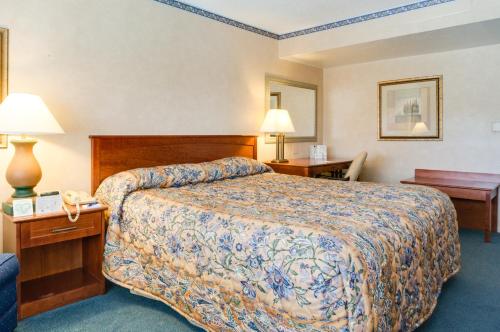 帕萨迪纳Saga Motor Hotel Pasadena的酒店客房,配有一张床、两张桌子和台灯