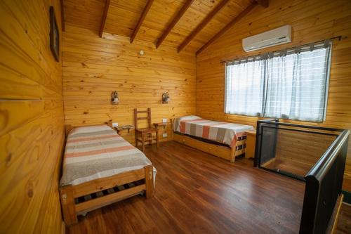 埃博森Complejo Turistico Bambu的小木屋内带两张床的房间