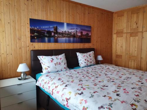 特施尔茨陈Aegerta Alte Schreinerei的卧室配有一张床,墙上挂有绘画作品