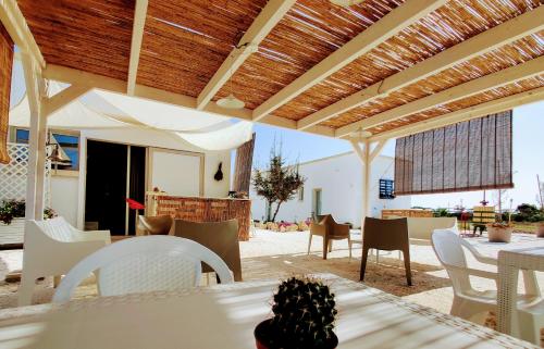奥特朗托Tenuta Sofia的庭院设有白色的桌椅和木制天花板。