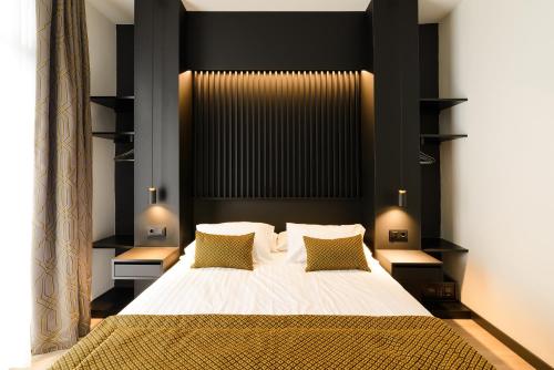 锡切斯Elite Hotel - Gay Men Only的一间卧室配有一张带黑色床头板的大床