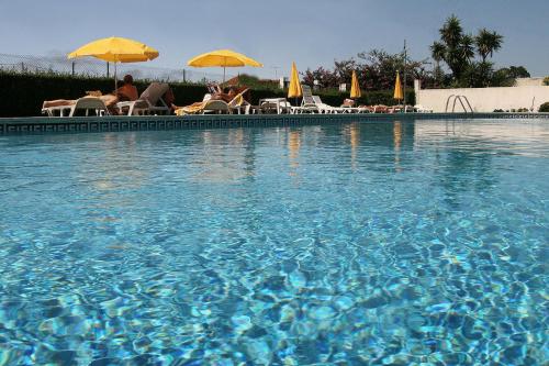托沙阿卡达酒店的游泳池里有人坐在伞下