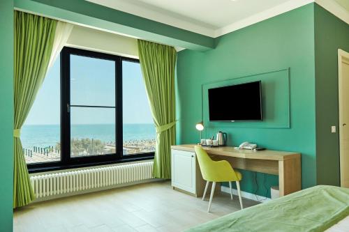 北马马亚-讷沃达里Hotel Excelsior Mamaia Nord的酒店客房设有书桌和窗户。