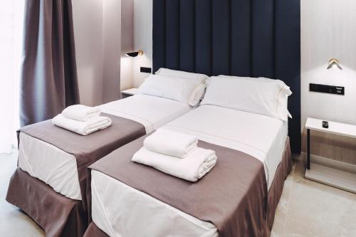 贝尼多姆GBH Hotel-Apartamentos Estrella de Mar的一间卧室配有两张床和白色毛巾。