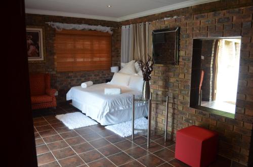 贝拉贝拉蒙里普斯旅客农场酒店的一间卧室设有一张床和砖墙