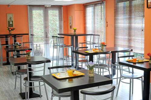 洛姆洛姆床先生酒店的用餐室设有桌椅和橙色墙壁