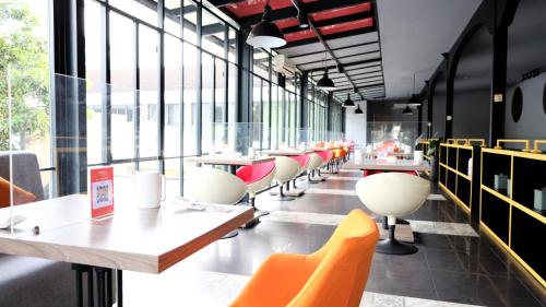 雅加达Moritz Hotel RSAB Harapan Kita的餐厅设有桌椅和窗户。