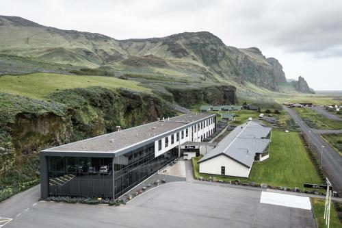 维克Hotel Vík í Mýrdal的山 ⁇ 的建筑的 ⁇ 染