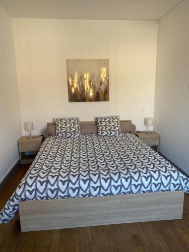 SeurreL’appartement de Rose的一间卧室配有一张大床,配有蓝色和白色的床罩