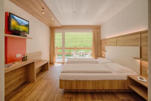 瓦尔奥纳的圣乔凡尼Oberjahrl的一间卧室设有两张床,墙上配有电视。