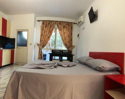 维利波吉Hotel Otrant的一间卧室配有一张带红色床头板的大床