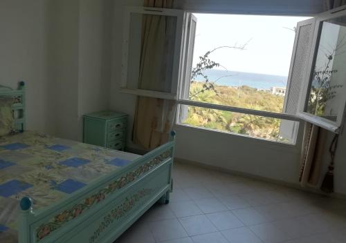 古莱比耶Azure Residences的一间卧室设有一张床和一个大窗户