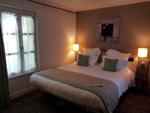 索姆河畔的圣瓦列里卡普霍尔努旅馆的一间卧室配有一张带绿色枕头的大床