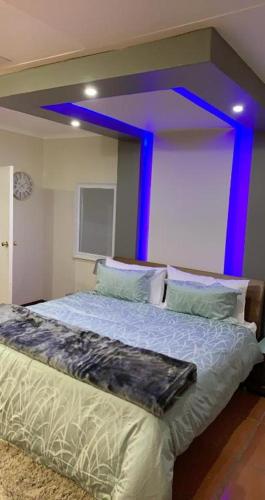 SandtonMade Guest House的一间卧室配有一张蓝色灯床